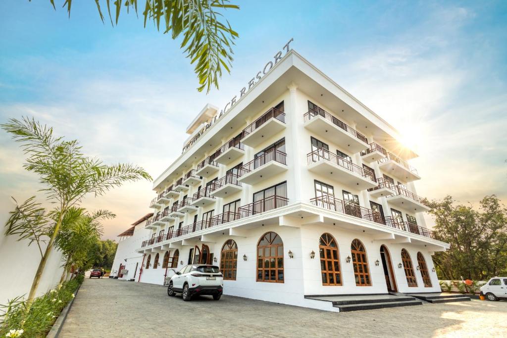 un edificio blanco con coches estacionados frente a él en Krown Palace Resort en Silvassa