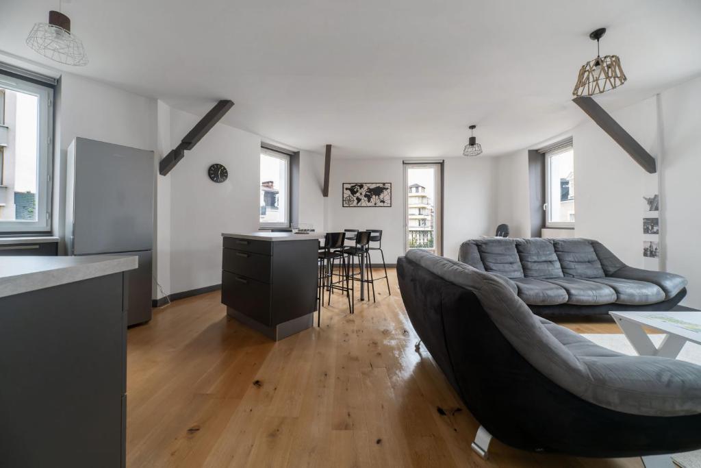 uma sala de estar com um sofá e uma mesa em Le Gramont - Grand appartement design, 3 chambres, Centre Ville em Vichy