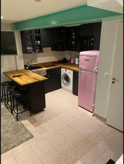 une cuisine avec un réfrigérateur rose et une table dans l'établissement PARIS Le Marais Duplex, à Paris