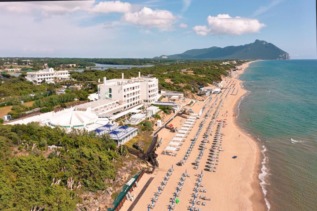 una vista aerea su una spiaggia con ombrelloni e sull'oceano di Hotel Oasi Di Kufra a Sabaudia