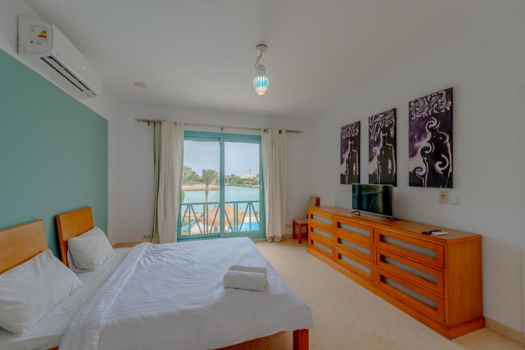 a bedroom with a bed and a television and a window at Stunning Villa for Rent in El Gouna HEATED PRIVATE POOL in Hurghada