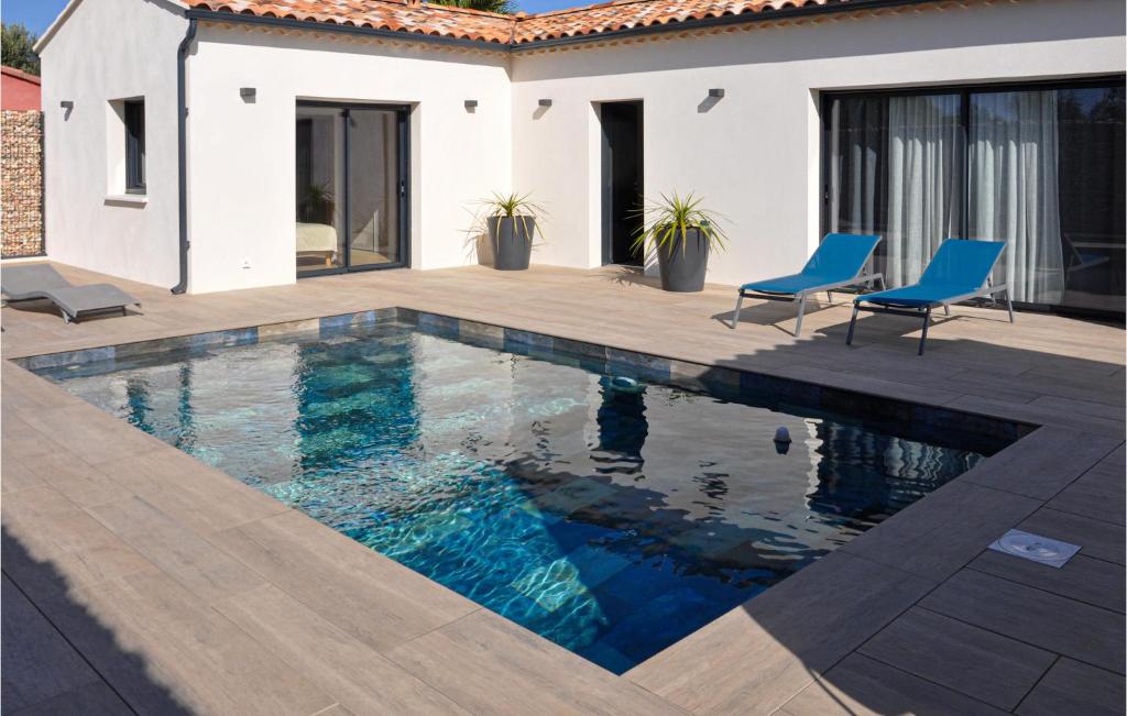einen Pool mit blauen Stühlen neben einem Haus in der Unterkunft Lovely Home In Bedarrides With Swimming Pool in Bédarrides