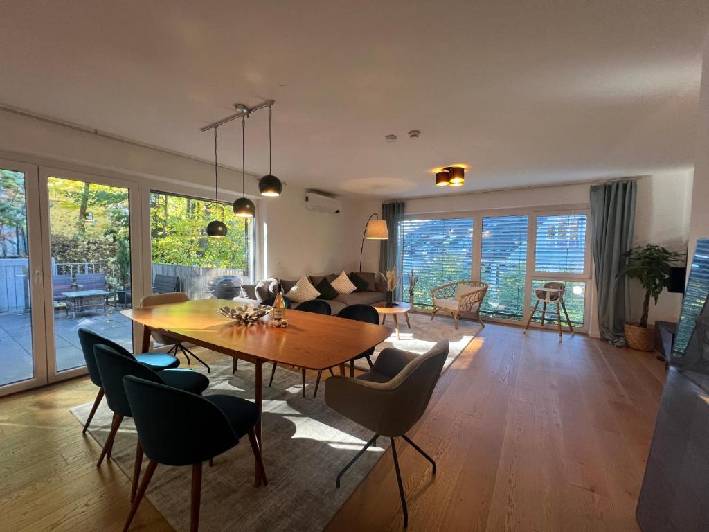 a living room with a wooden table and chairs at LIBORIA I Stylisches Haus I Sauna I Wellness in Starnberg