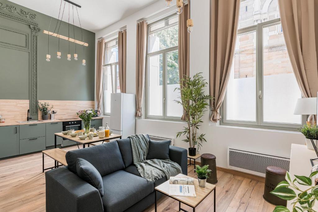a living room with a couch and tables at Charmant & spacieux appartement en cœur de ville in Saint-Étienne