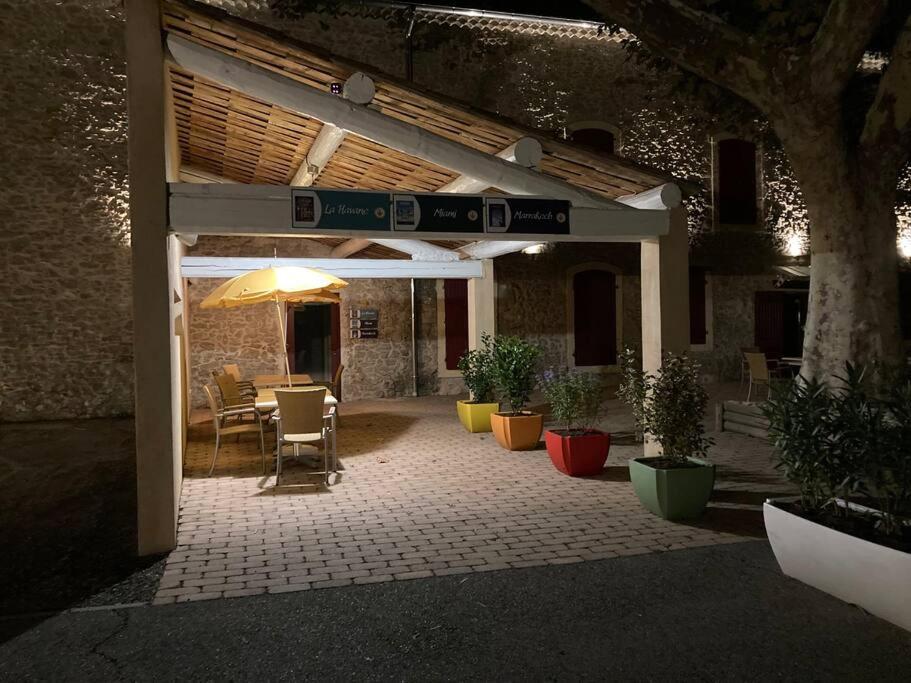 une terrasse avec une table, des chaises et un parasol dans l'établissement Studio «  Lisbonne » à Avignon, à Avignon