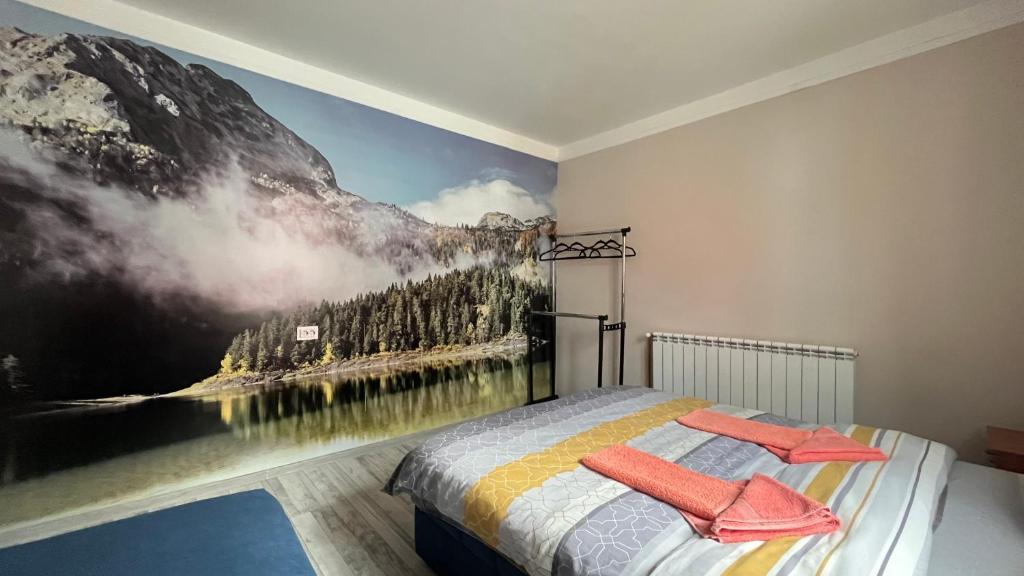 a bedroom with a mountain mural on the wall at SNAM Rooms&Apartment in Žabljak