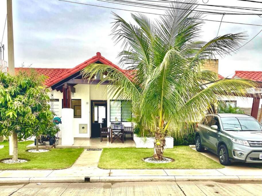 a car parked in front of a house with a palm tree at HERMOSA Y COMODA CASA " En condominio Privado " in Santa Cruz de la Sierra