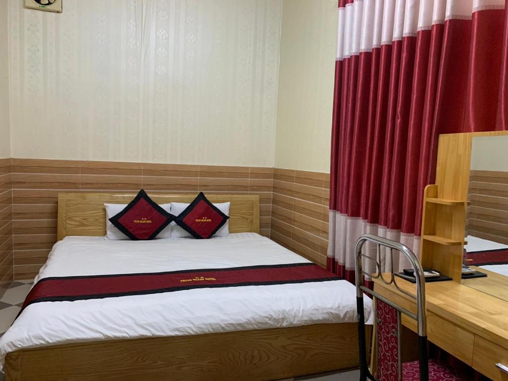 - une petite chambre avec un lit et un rideau rouge dans l'établissement KHÁCH SẠN PHỤNG HOÀNG, à Quang Tri