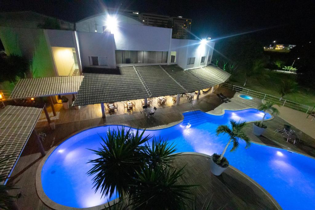 an overhead view of a large swimming pool at night at Hotel BHS in Linhares