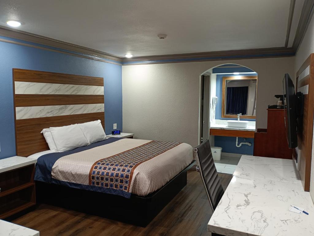 1 dormitorio con 1 cama y lavamanos. en Americas Best Value Inn & Suites-Alvin/Houston, en Alvin