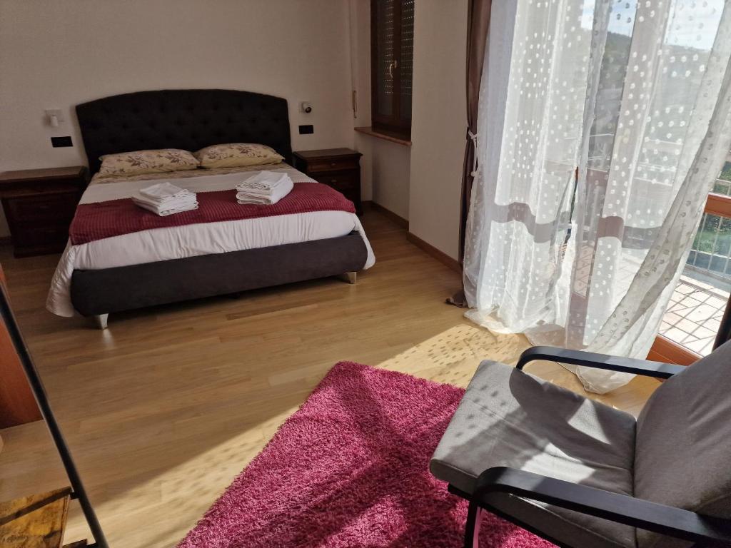 a bedroom with a bed and a chair and a window at Nataly in SantʼAmbrogio di Valpolicella