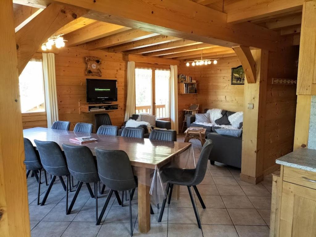 una sala da pranzo con un grande tavolo in legno e sedie di Chalet Le Grand-Bornand, 7 pièces, 13 personnes - FR-1-467-31 a Le Grand-Bornand