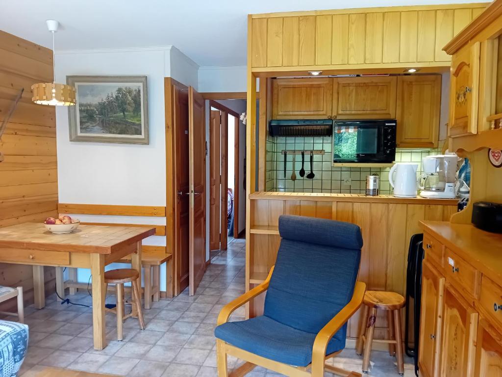 une cuisine avec une table et une chaise bleue dans l'établissement Appartement cosy pour 6 au Grand-Bornand, proche centre et navette gratuite - FR-1-467-122, au Grand-Bornand