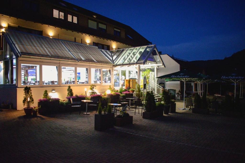 ein Restaurant mit Tischen und Stühlen vor einem Gebäude in der Unterkunft Hotel & Restaurant Olio é Pane in Enzklösterle