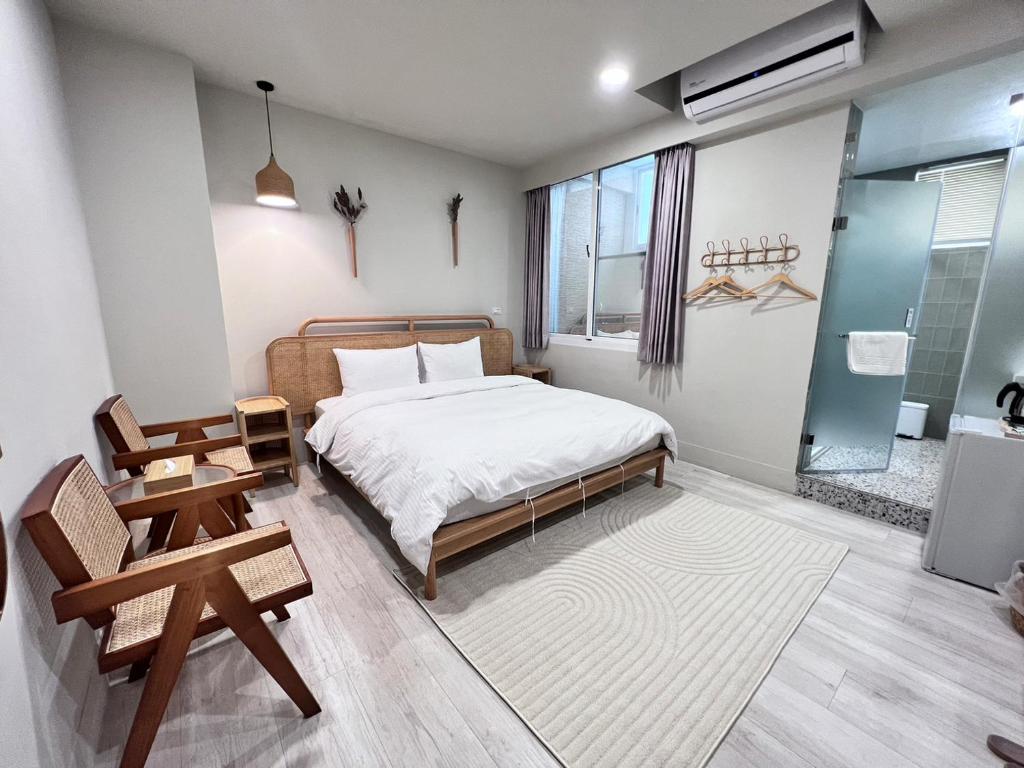 台南的住宿－河趣泊旅 River Chill Inn，一间卧室配有一张床、一把椅子和一张桌子