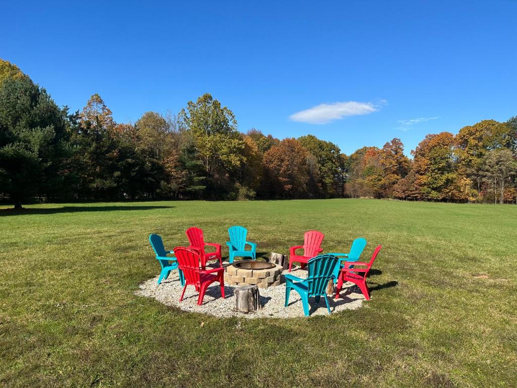 a group of colorful chairs sitting around a fire pit at Spacious Cozy Getaway ! King Bed, Game Room, Out Door Patio in Cairo