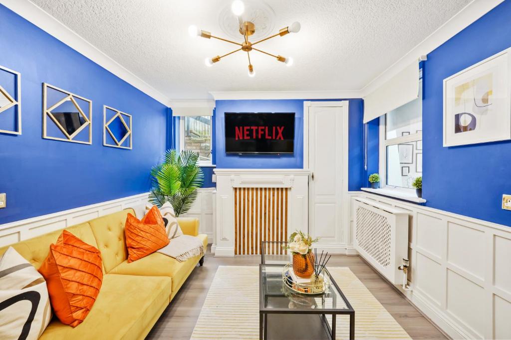 a living room with blue walls and a yellow couch at Luxury 1 Bed Retreat With Free Parking - FREE NETFLIX & WIFI in Chatham