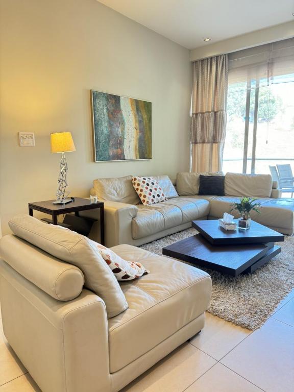 een woonkamer met een bank en een tafel bij Abdoun Falls Luxury Apartment in Amman