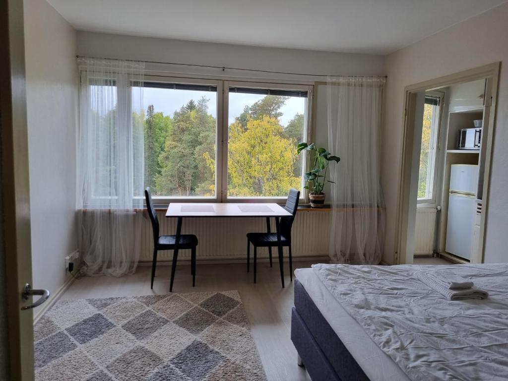 a bedroom with a bed and a table and a window at 6. kerroksen yksiö lähellä matkakeskusta. in Lappeenranta