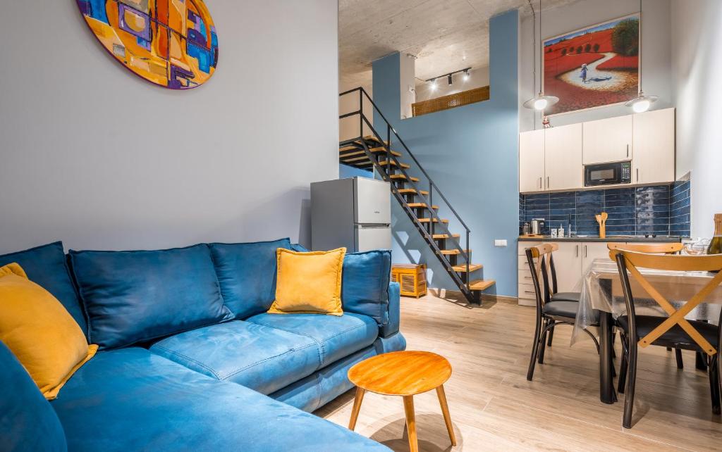 uma sala de estar com um sofá azul e uma mesa em Roshka 2 BD Apart 501 em Gudauri