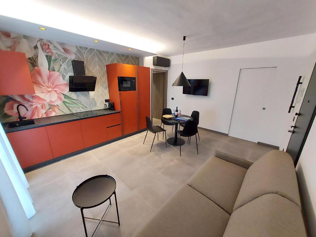 uma sala de estar com um sofá, uma mesa e cadeiras em ApartmentsGarda - Residenza Garda Deluxe em Garda