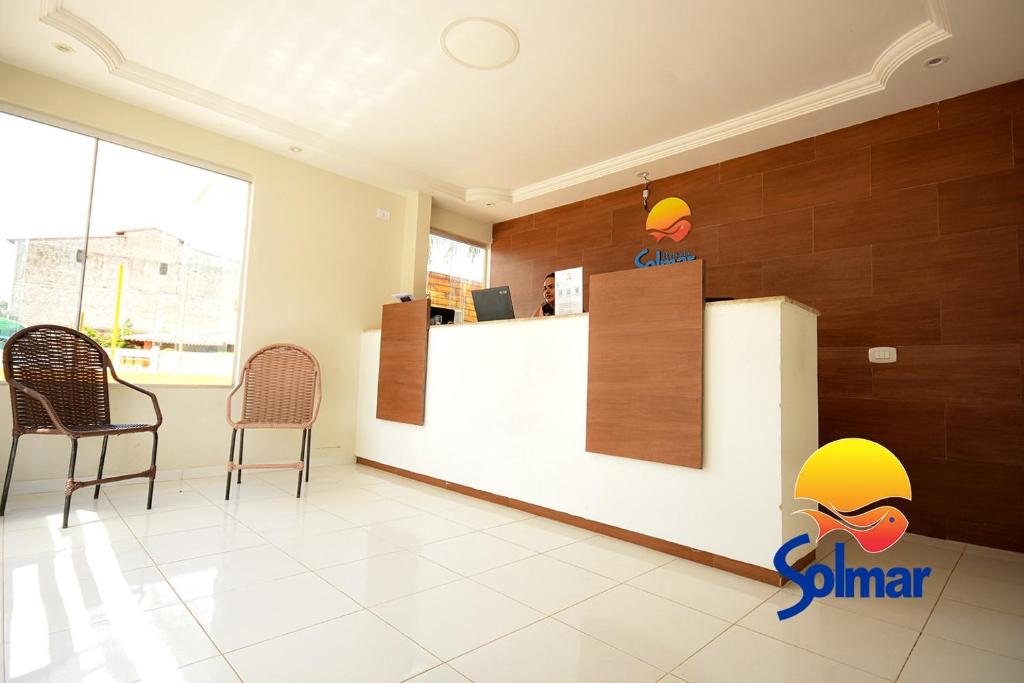 a sun star office with chairs and a counter at Pousada Solmar in Japaratinga
