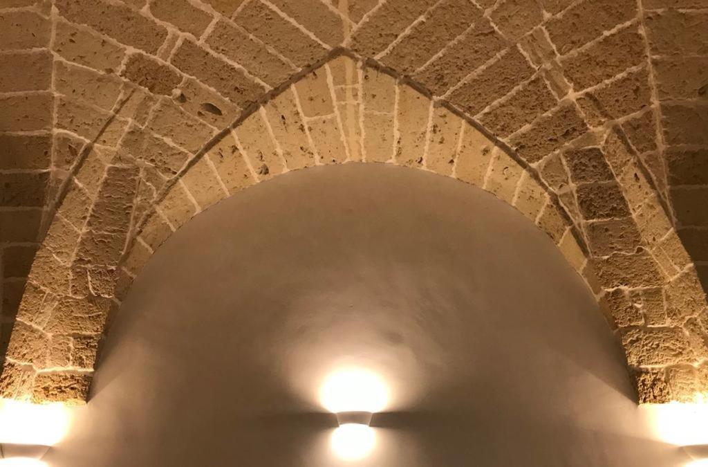 un arco en una pared de ladrillo con dos luces en Happy Loft Salento, en Cellino San Marco