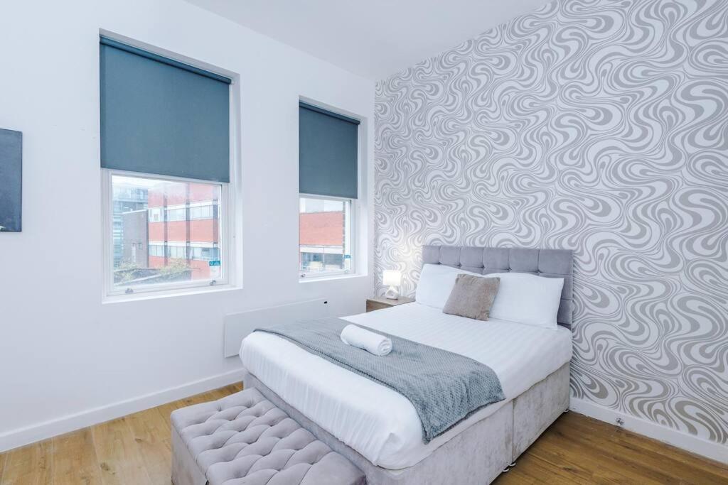 ein Schlafzimmer mit einem Bett und einer Wand mit einem Muster in der Unterkunft Stylish Apartment located in the City Centre of Liverpool - Sleeps 5 in Liverpool