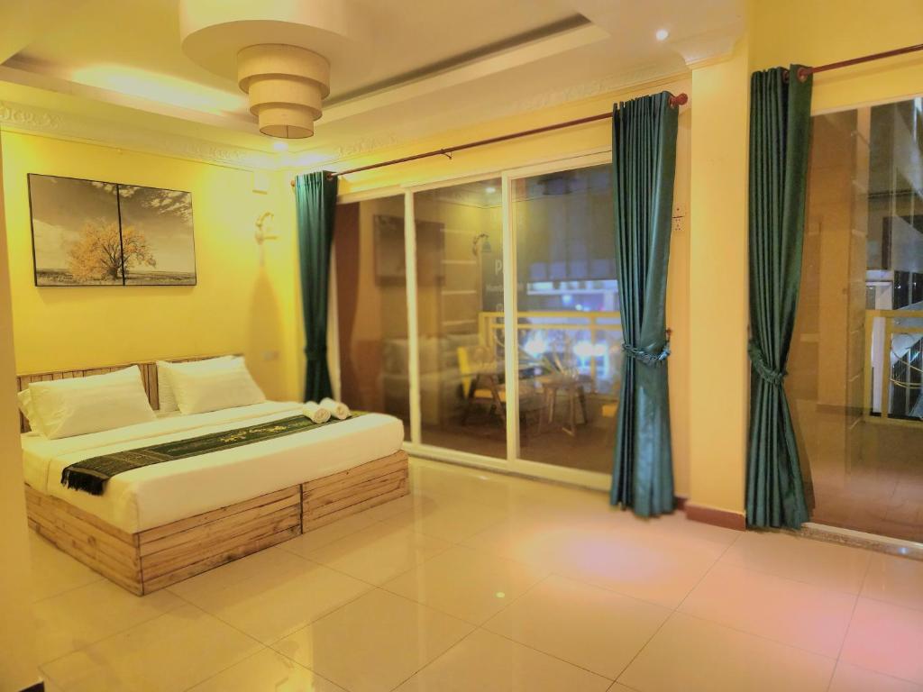 1 dormitorio con cama y ventana grande en SOMA HOTEL, en Phnom Penh