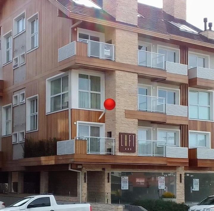 uma bola vermelha no ar em frente a um edifício em LOFT 235 CANELA em Canela