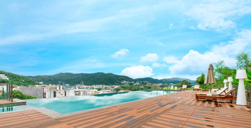 卡塔海灘的住宿－Rudi Condo by Q Conzept，从带游泳池的建筑屋顶上欣赏美景