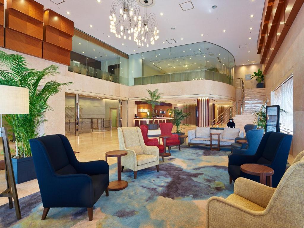a lobby of a hotel with chairs and tables at Mitsui Garden Hotel Kumamoto in Kumamoto
