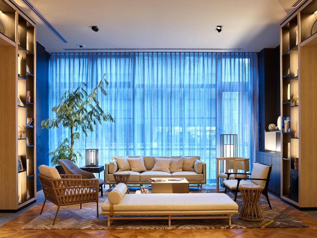 a living room with a couch and a large window at Mitsui Garden Hotel Fukuoka Gion in Fukuoka