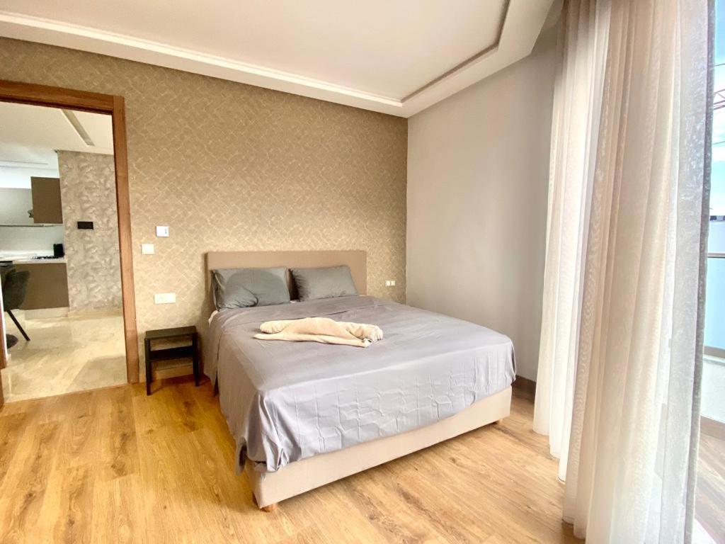 Un dormitorio con una cama con una manta blanca. en Résidence Saad, app 53 en Casablanca
