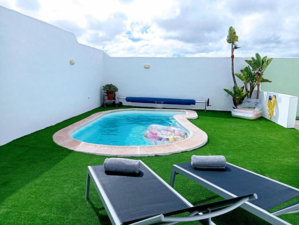 a backyard with a swimming pool and green grass at Casa Strelitzia in Nazaret