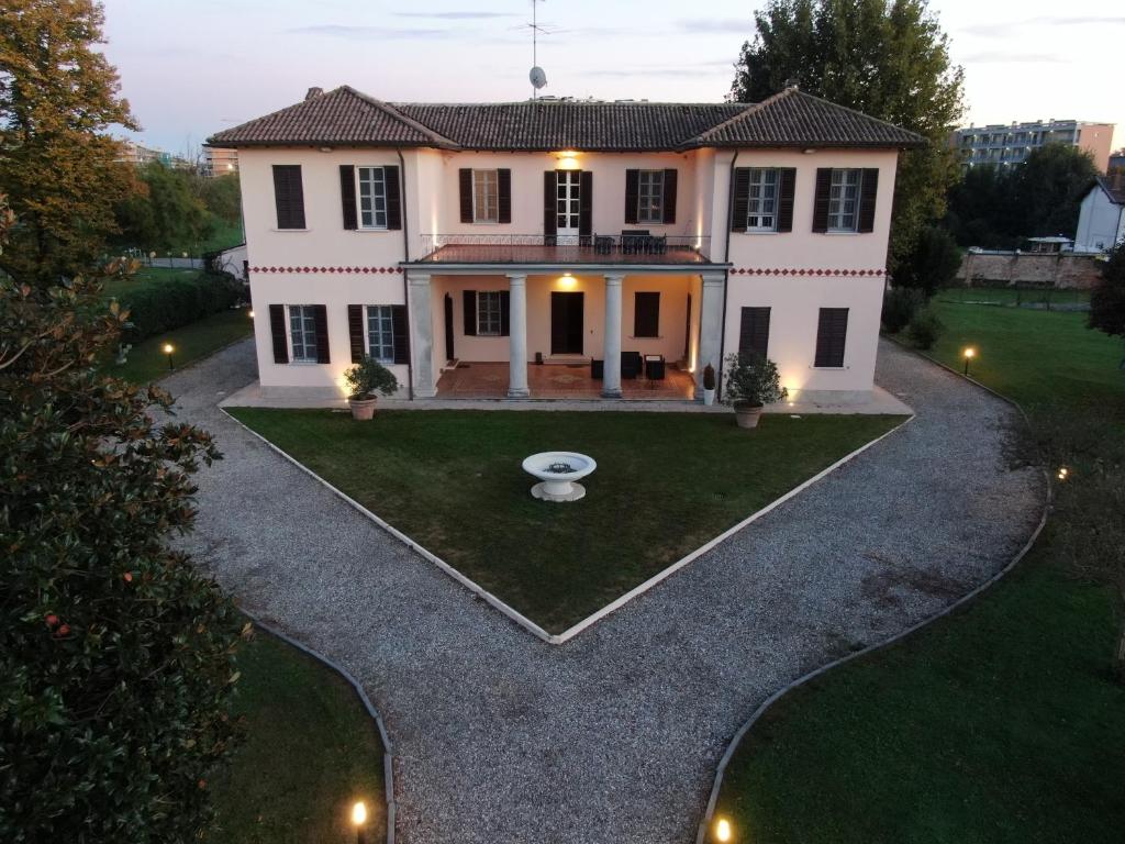 a house with a fountain in the yard at Suites Mansion in Rozzano