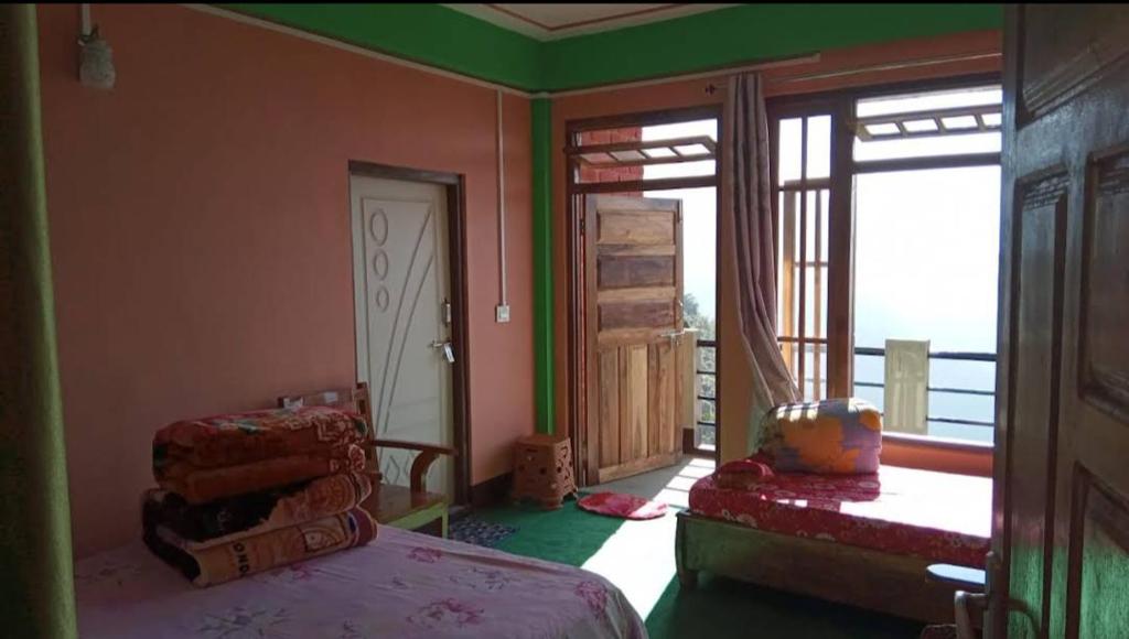 um quarto com uma cama e uma porta aberta para uma varanda em Sunyog Homestay em Pedong