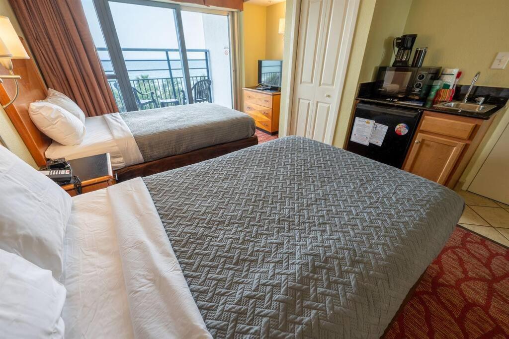 a hotel room with two beds and a window at Oceanfront Convenience on Lower Floor, Heated Pool in Myrtle Beach