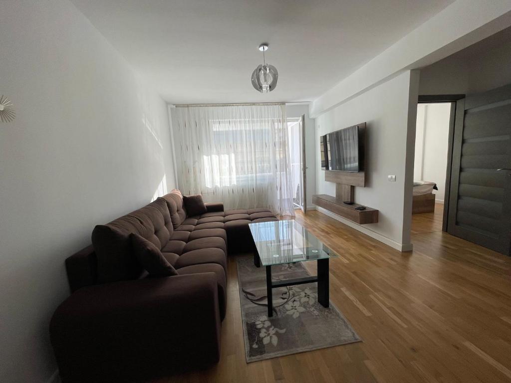 a living room with a brown couch and a glass table at Lucky Home Timisoara 2 in Timişoara