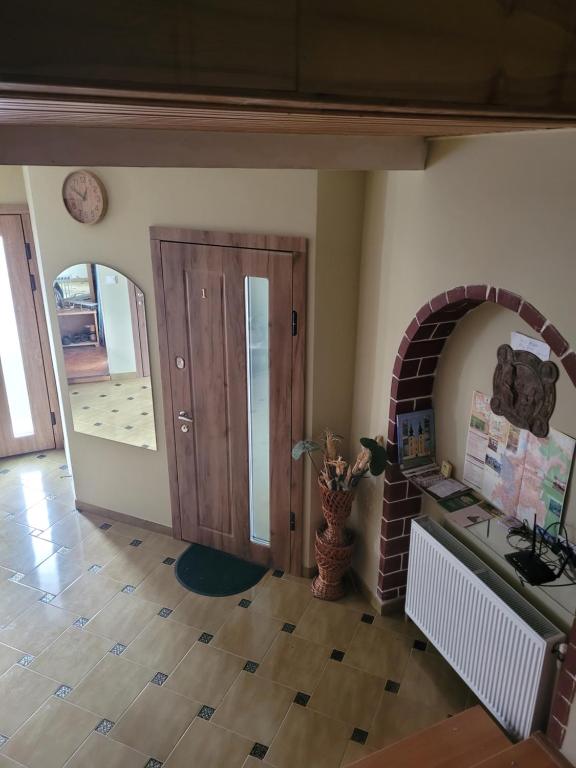uma sala de estar com uma lareira de tijolos e uma porta em M&M APARTMENTS em Berehove