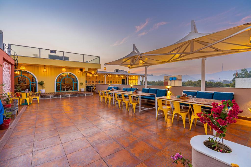 un patio al aire libre con mesas y sillas y un restaurante en Blue Door, en Bundi