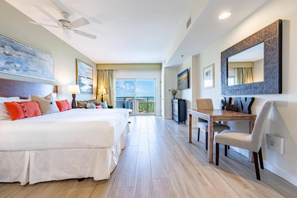 a bedroom with a large bed and a desk with a table at Luau I 7605 Studio in Destin