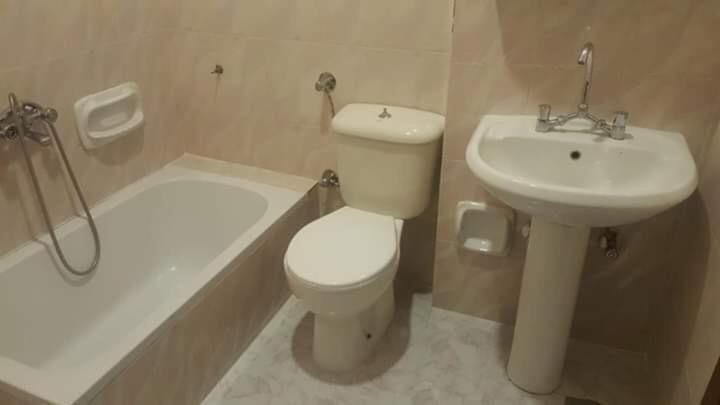 een badkamer met een toilet, een wastafel en een bad bij فندق الامرات ٣٣ النيل in ‘Izbat al Jirabī