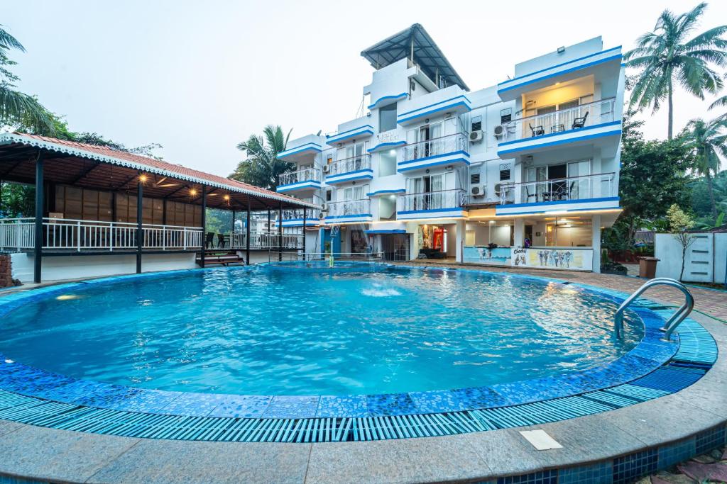 a large swimming pool in front of a building at Treebo Trend Gulmohar Beach Resort in Calangute