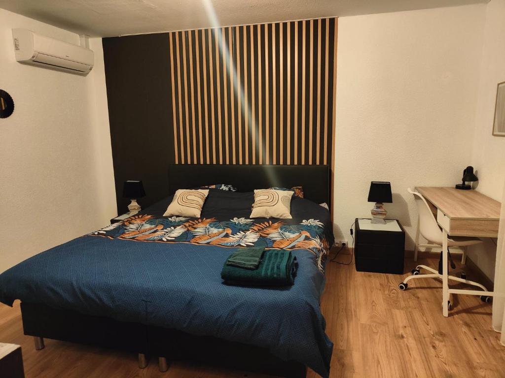 サン・ルイにあるChambre climatisée cosy Auberge du Manala Hôtel 24-24のベッドルーム1室(青い毛布、デスク付)