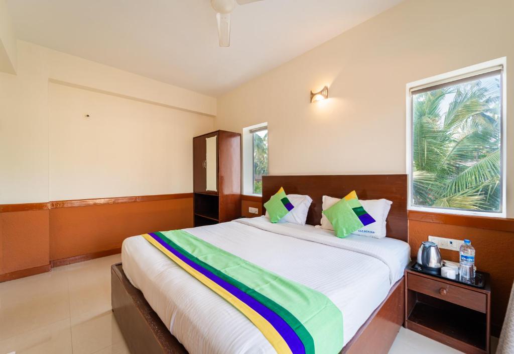 Postel nebo postele na pokoji v ubytování Treebo Gulmohar Beach Resort
