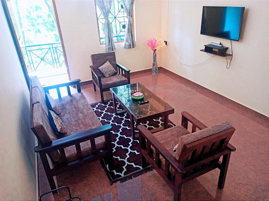 a living room with chairs and a table and a tv at Benirosa Homestay Apartments 2 in Velcao