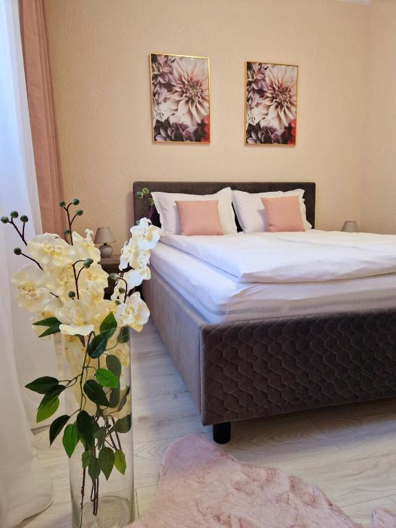 a bedroom with a bed and a vase with flowers at ORI Passion Apart. Malul Mureșului in Arad