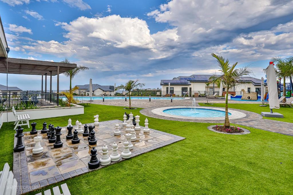 535 Ballito Hills 2 Bedroom unit في باليتو: لوحة شطرنج على عشب مع مسبح