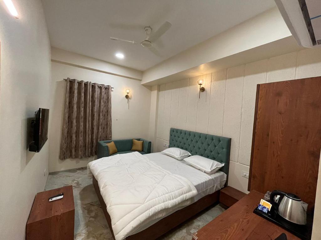 a bedroom with a large bed with a green headboard at Kasa Comfort Inn in Indore